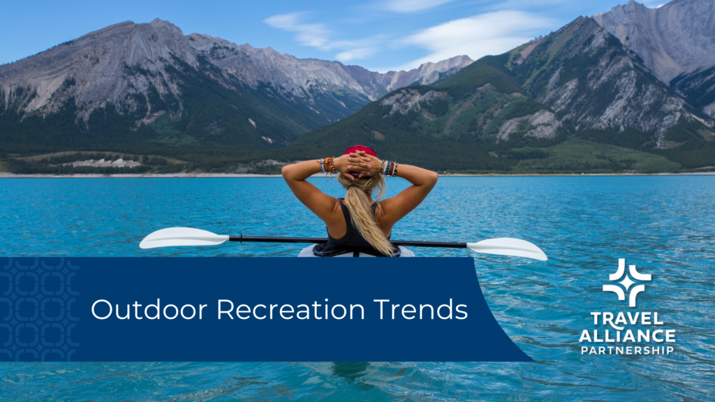 A woman in a kayak looks across the lake to mountains. Overlaid text on a blue bar reads "Outdoor Recreation Trends".