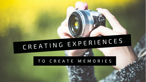 somebody taking a picture with camera with text "creating experiences to create memories".